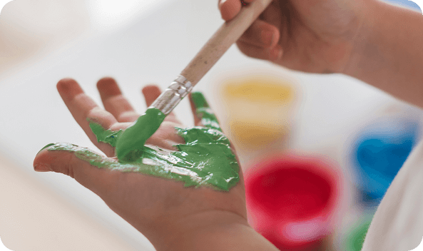 A child's hand gripping a paintbrush